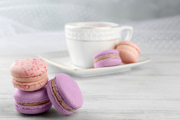 Tasty macaroons with tea on wooden table