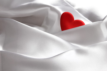 Red heart on white silk