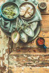 Aged spoons and rustic plates with flavoring on wooden background, top view, place for text