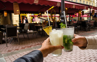 Cocktails in the hands of two friends.