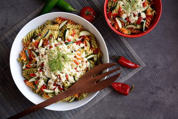 Pasta salad with zucchini, onion, garlic, chili and mozzarella