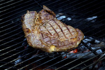 beef steak cooking on an open flame grill