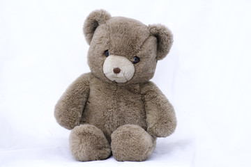 stuffed toy bear standing on a white background .