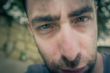 Obraz premium Close up portrait on the face of a young man with a serious expression