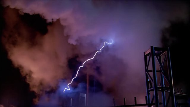 Electric arcs striking metal trusses with lurid clouds in background