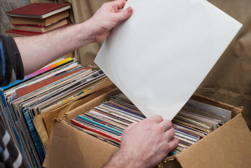 Retro styled image of a collection of old vinyl record lp's with sleeves on a wooden background....