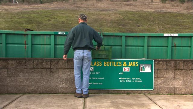Man sorting glass into recycle bin