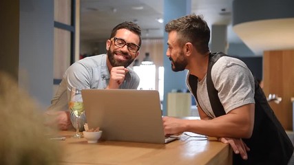 Trendy guys in bar connected with laptop