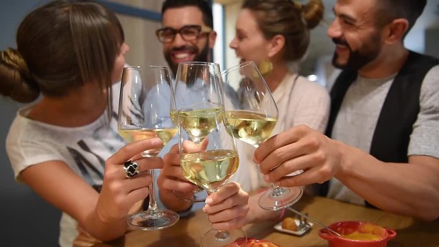 Group of trendy people cheering with wine glasses