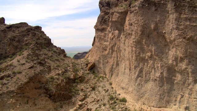 Flying through a notch in sandstone cliffs to reveal a wide valley. Shot in 2007.
