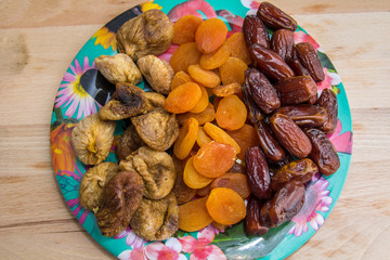 plate of tasty dried figs, apricots and dates