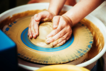 child working on potter's wheel