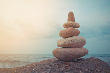 Stone tower on a pebble beach. Vintage tone.