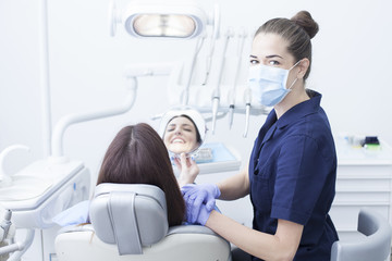 Obraz premium Beautiful woman patient having dental treatment at dentist's office. Woman visiting her dentist