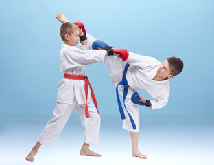 Athletes fight in a kimono and with different belts on the combined background
