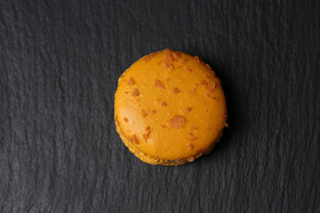 French orange macarons on black background