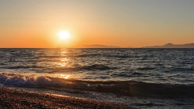 sun sets behind horizon and the rocks in sea Greece Aegean evening