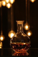 Round bottle with drink against blur bokeh light