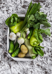 Fresh green and white vegetables - cucumbers, peppers, radish, radish, garlic, onion, potato, zucchini on a light background. Healthy vegetarian food