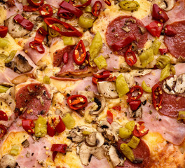 Italian pepperoni pizza with ham, red peppers and cheese