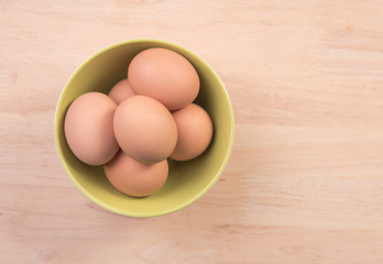 Fresh eggs ingredient in bowl on wooden table rustic background