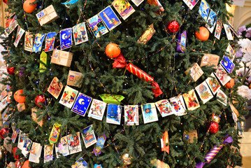 Christmas tree decorated with Christmas balls, candy and garland of old postcards at State Department Store