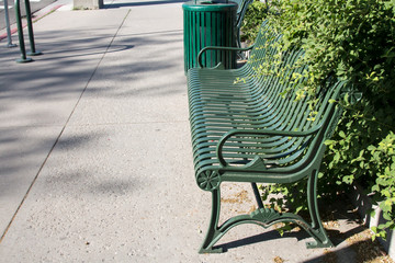 Overgrown park bench on a sidewalk