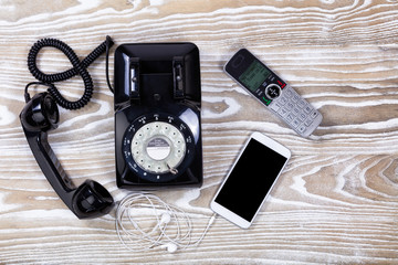 Retro telephone with modern communication devices on faded wood