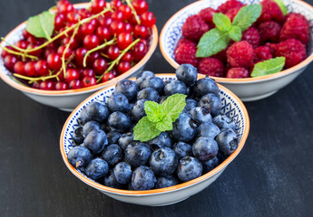 Fresh healthy berries in rustic bowls with mint