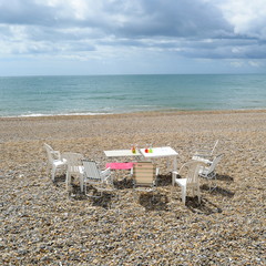 Fototapeta na wymiar Empty table and chairs on Jurassic Coast in Seaton, Devon