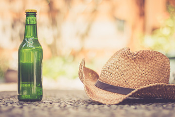 Bierflasche mit Strohhut, Ferien