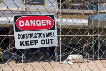 Danger construction area keep out sign in front of building under construction
