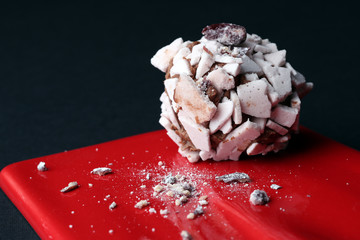 Sweet dessert. Delicious meringue on the red plate, black background