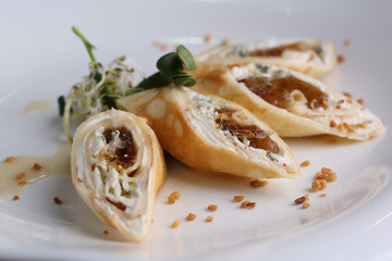 Food pancake with cream cheese, greens and jelly on a white plate, molecular cuisine, closeup.