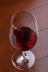 Glass of red wine on wooden table. Close up