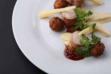 Baked meat rabbit roll and rissole with chees, souses on white plate. Close up
