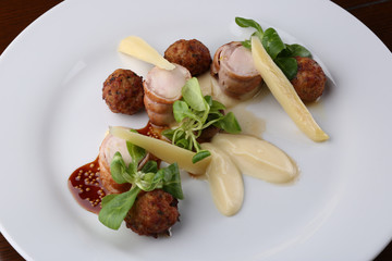 Baked meat rabbit roll and rissole with chees, souses on white plate. Close up