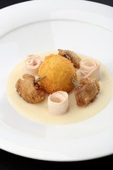 Chicken Balls -  breaded, deep fried balls filled with egg and Chickens legs served bacon, celery puree on white plate. Close up