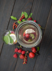 Glass bottle with drink of mint and berries