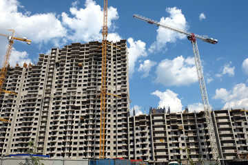 Fototapeta na wymiar New high-rise modern apartment buildings construction in process ob bright sunny day front view horizontal