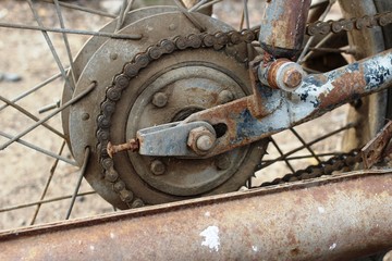 A very old and dirty motorcycle in a rural place