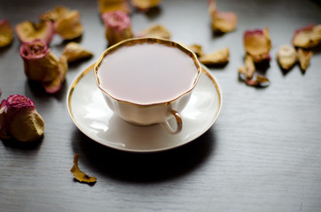 herbal rose tea in a porcelain Cup on a dark wooden background