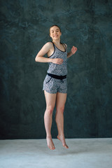 Naklejka premium Sexual sports girl with a good body goes in for sports and youga on a dark background