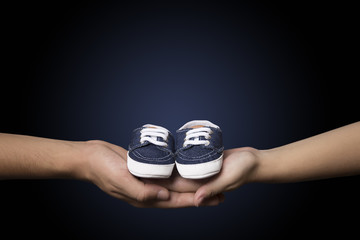 Couple holding blue baby shoes