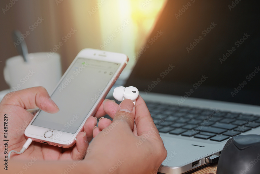 Poster selective focus of hands holding hand holding earphone and blank screen of white smartphone device o