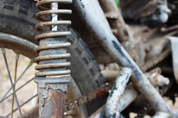 A very old and dirty motorcycle in a rural place