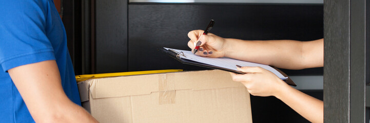 Woman signing parcel delivery papers