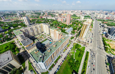 Fototapeta premium Aerial city view with crossroads and roads, houses, buildings, parks and parking lots, bridges. Copter shot. Panoramic image.