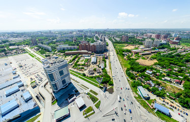 Aerial city view with crossroads and roads, houses, buildings, parks and parking lots, bridges. Urban landscape. Copter shot. Panoramic image.