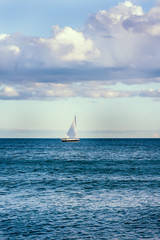 Lake landscape with a sail boat in the distance
